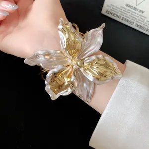 Detailed view of luxury vintage lily flower cuff bracelet with gold and pearl texture
