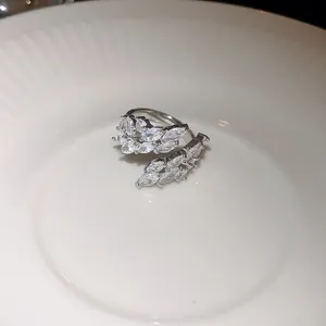 Gros plan d'une bague ouverte en argent avec des pierres marquises en forme de feuilles