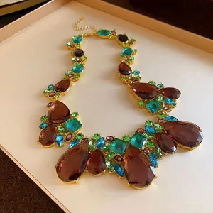 Vista detallada de un collar llamativo con cristales de colores estilo vintage en forma de gota.