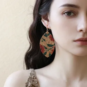 Detaillierte Nahaufnahme eines blattförmigen Korkohrrings mit vintage roten Blumenmustern