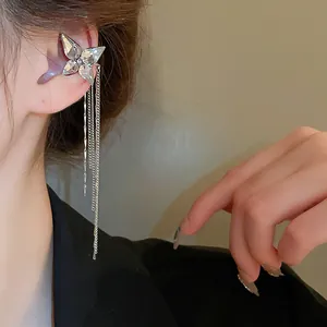 Close-up detail of silver butterfly ear cuff with three-layered long chain tassels