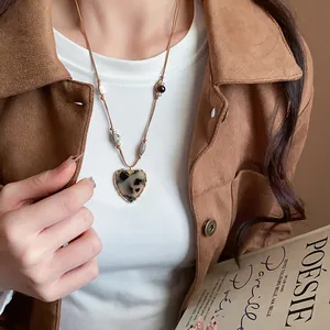 Detailed view of a vintage Maillard style heart pendant necklace with tiger eye beads.