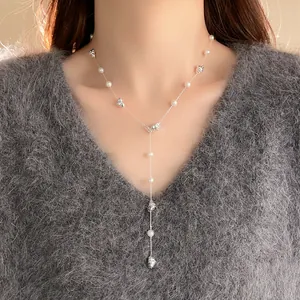 Nahaufnahme einer silbernen Perlenhalskette mit geometrischen Elementen auf einem Pullover