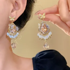 Vue détaillée de boucles d'oreilles papillon ornées de cristaux goutte d'eau