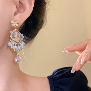 Détail de boucles d'oreilles papillon vintage avec pampilles de strass en gouttes