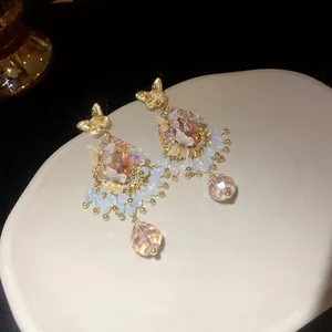 Gros plan détaillé de boucles d'oreilles papillon vintage avec cristaux roses et perles