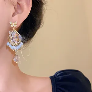 Vue détaillée de boucles d'oreilles vintage en cristal avec pampilles papillon sur l'oreille