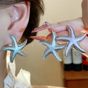 Close-up detail of silver needle enamel starfish earrings in light blue and purple