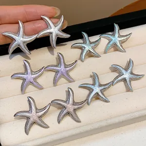 Detailed macro view of silver needle starfish earrings with colorful drip oil finish
