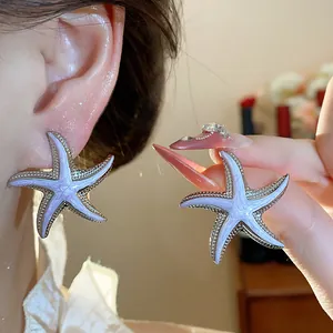 Detailed view of lilac dripping oil starfish stud earrings with silver needles