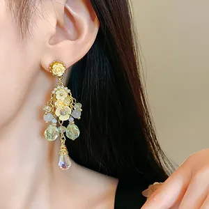 Elegant floral chandelier earrings with pearls and crystal drops shown on a model