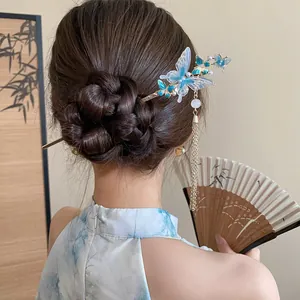 Dettaglio di un elegante bastoncino per capelli a farfalla blu con lunghe nappe dorate