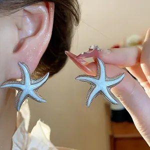 Detailed view of elegant white enamel starfish stud earrings for a seaside vacation style