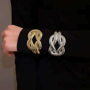 Statement gold and silver acrylic wide knot horseshoe buckle bangles on model arm