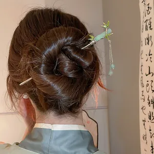 Dettaglio di un fermaglio per capelli cinese vintage in bambù con perline pendenti