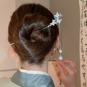 Dettaglio forcina per capelli a farfalla con lunghe nappe su chignon