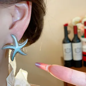 Detailed view of a stylish silver-toned starfish stud earring with light blue enamel