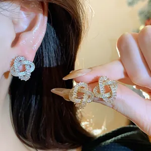 Detailed close-up showing 18k gold plated zircon entwined stud earrings for women's wear