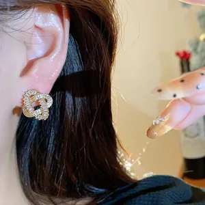 Exquisite 18k gold-plated zircon entwined stud earrings shown in a close-up detail view.