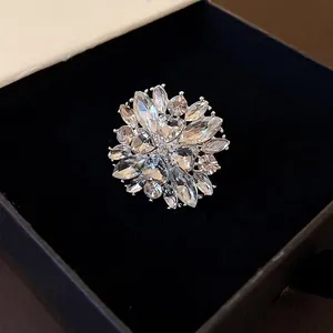 Elegant flower-shaped silver ring with sparkling white crystals in a premium gift box.