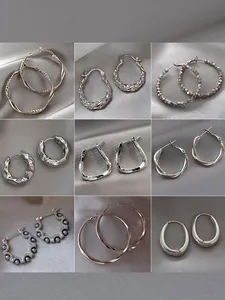 Collection of various silver hoop earrings featuring textured, beaded, and stone designs