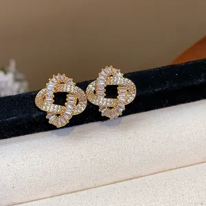 Macro view of gold-plated twisted stud earrings set with sparkly zirconia