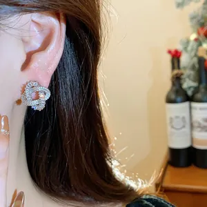 Close-up of elegant zircon-encrusted knot stud earrings with a sparkling luxury finish
