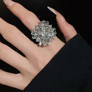 Detailed close-up of a sparkling flower-shaped crystal ring on a model's finger.