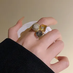 Close-up of gold-plated open ring featuring sparkling zircon ball and crystal stones.
