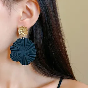 Detailed close-up of a black mint leaf petal earring worn on a model's ear