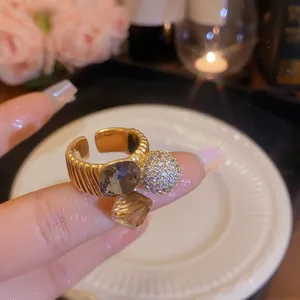 Close-up of gold-plated open ring with glittering zircon spheres and smoky gemstones.