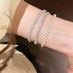 Detail shot of elegant French zircon mesh wrap bracelet and pearl strand on wrist