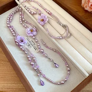 Elegant purple pearl necklace with fabric flowers and crystal teardrop pendants accessory.