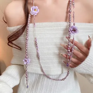 Elegant long necklace featuring purple pearls, cloth flowers, and stylish tassel accents