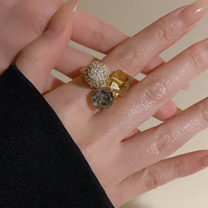 Close-up detail of a high-end gold-plated open ring with zircon pavé and grey stone