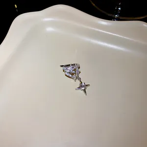 Detail shot of a sparkling rhinestone star ear cuff on a beige decorative tray