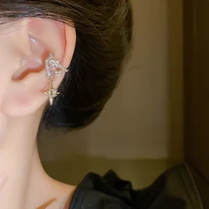 Close-up detail of elegant silver rhinestone star ear cuff with zircon dangle charm.