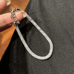 Close-up of elegant zircon mesh wrap bracelet with silver clasp and chain detail.
