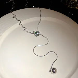 Elegant silver-tone adjustable lariat necklace featuring a green zircon and metallic sphere