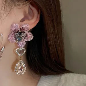 Boucles d'oreilles asymétriques fleurs roses brodées avec cœurs et cristaux poire.
