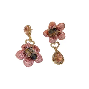 Boucles d'oreilles asymétriques fleurs en cristal avec pétales roses et finition dorée