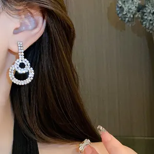 Close-up view of elegant double circle silver needle earrings with shimmering rhinestones