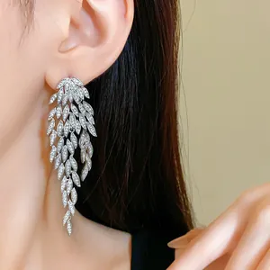 Close-up view of elegant leaf-shaped tassel earrings with sparkling stones on model