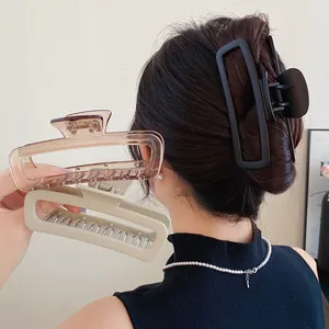 Vue détaillée de pinces à cheveux rectangulaires minimalistes en noir mat et acrylique
