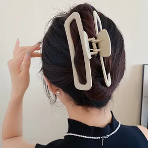 Vue arrière d'une pince à cheveux rectangulaire beige en acrylique sur un chignon