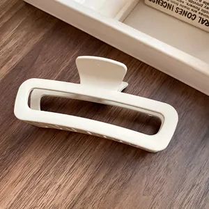 Vue détaillée d'une pince à cheveux rectangulaire évidée en acrylique blanc crème
