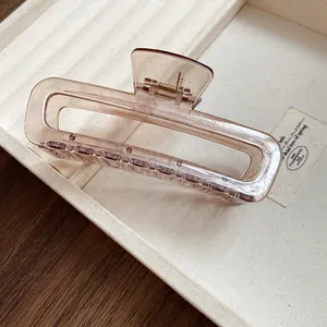 Vue détaillée d'une pince à cheveux minimaliste en acrylique marron transparent ajouré