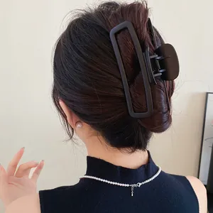 Vue arrière d'une grande pince à cheveux rectangulaire noire mate sur un modèle