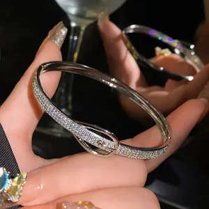 Detailed view of a silver belt buckle bangle fully paved with sparkling micro-zircons on hand