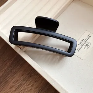 Détail d'une pince à cheveux rectangulaire noire mate en acrylique pour cheveux épais